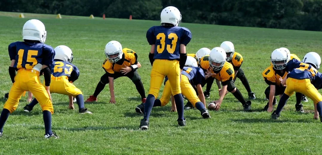 Children playing sport wearing protective gear